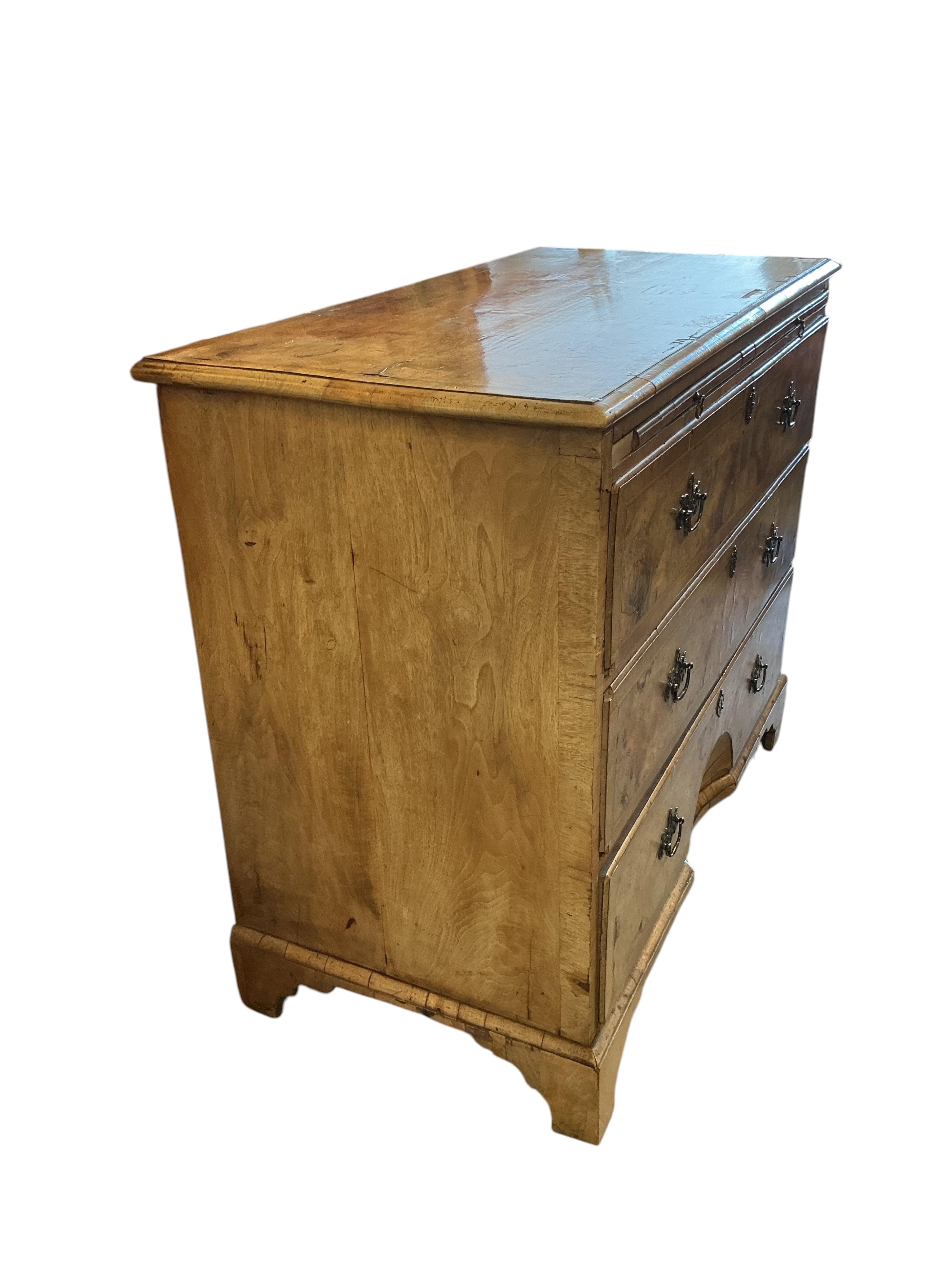 A mid 18th century feather banded walnut concave starburst walnut chest of three drawers, with brushing slide, width 108cm, depth 54cm, height 92cm